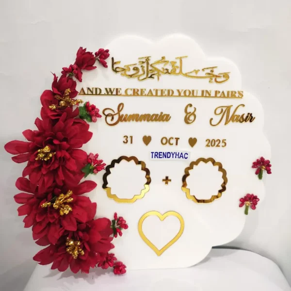 Full view of a curved shape white acrylic thumb impression board with gold lettering and a crescent border of brownish-red-flowers.