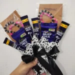 Side perspective view of the mini chocolate and bracelet gift package highlighting the black ribbon bow tie.
