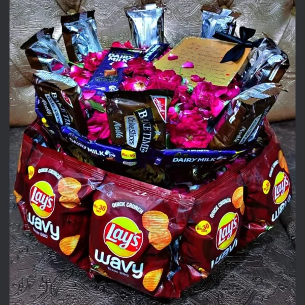 Full view of a multi-layered deluxe snack and chocolate gift tower hamper decorated with festive ribbons.