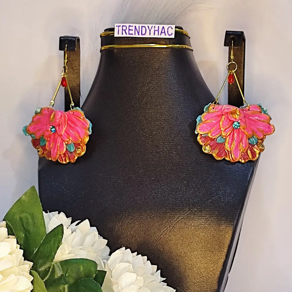 Pair of large fan-shaped hot pink clay floral earrings with gold trim and blue rhinestones displayed on a black neck stand with a TRENDYHAC label.