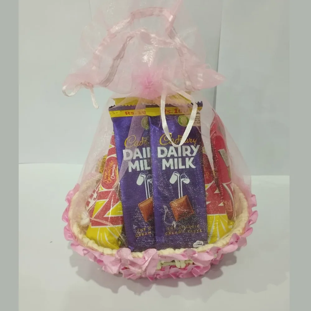 Front view of a pink-themed chocolate gift basket with Cadbury Dairy Milk bars wrapped in pink organza mesh.