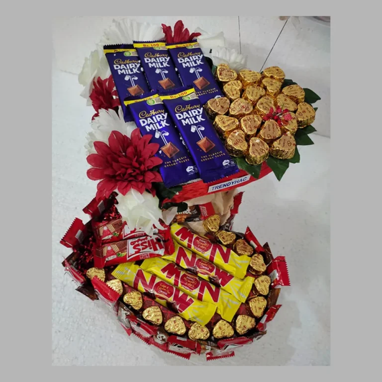 Full view of a double-decker heart-shaped chocolate gift tower with Cadbury Dairy Milk, Now, and Hiss bars decorated with red flowers.