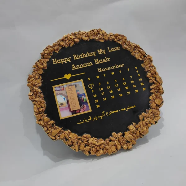 Flat lay view of a circular black resin birthday plaque with a gold geode rim, November calendar layout, and custom photo.