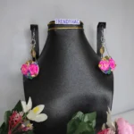 Pair of silver geometric drop earrings featuring clusters of pink clay roses and tiny colorful crystals, displayed on a black jewelry bust with a TRENDYHAC label.