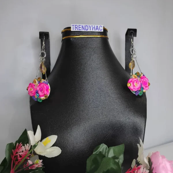 Pair of silver geometric drop earrings featuring clusters of pink clay roses and tiny colorful crystals, displayed on a black jewelry bust with a TRENDYHAC label.