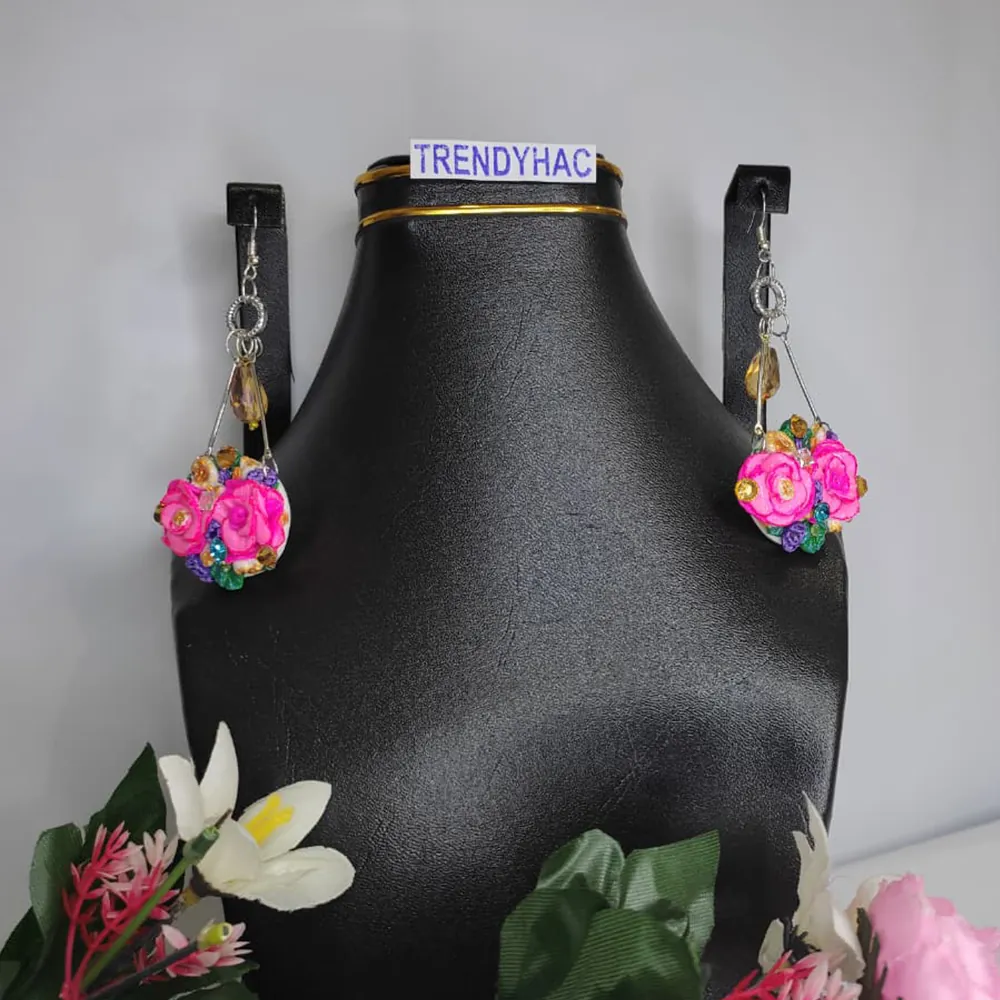 Pair of silver geometric drop earrings featuring clusters of pink clay roses and tiny colorful crystals, displayed on a black jewelry bust with a TRENDYHAC label.