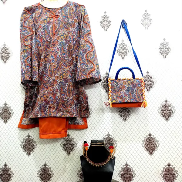 A blue and orange paisley patterned dress hanging next to a matching fabric flap shoulder bag and a coordinated beaded jewelry set on a black stand.