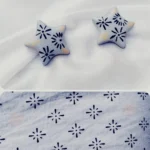 Perspective view highlighting the clean profile edges of the star stud earrings and the custom-printed display layout.